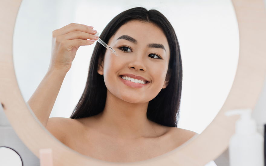asiatin trägt serum auf