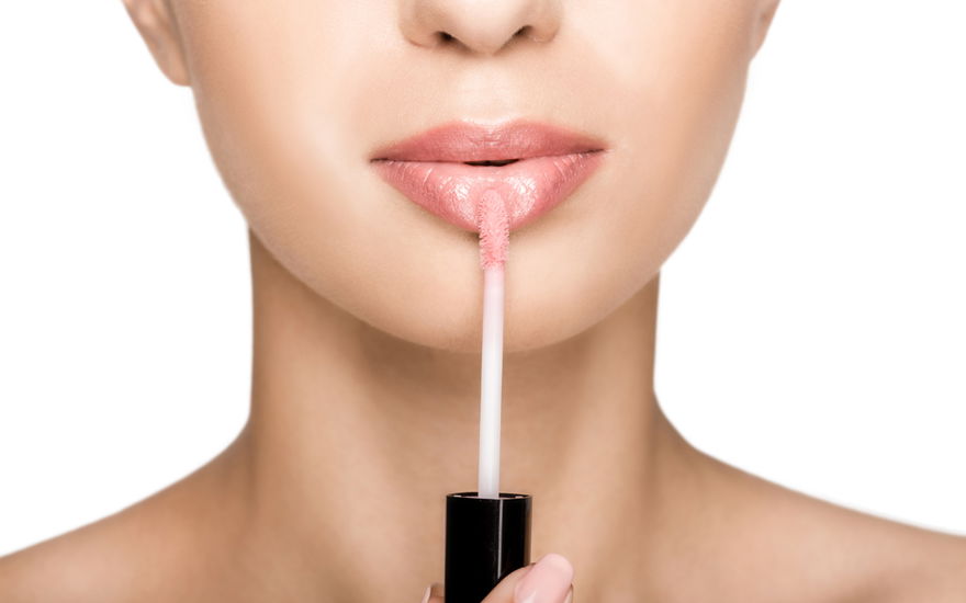 Frau trägt Lippenöl auf