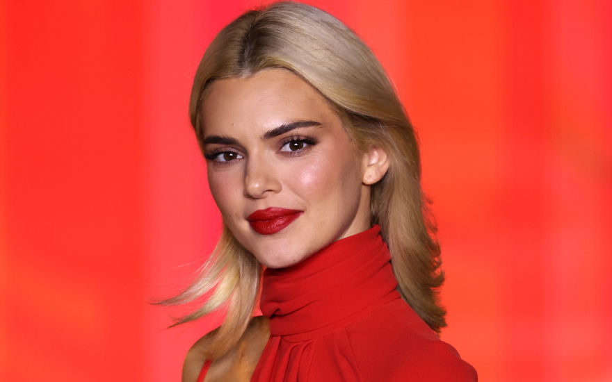 kendall jenner mit blonden haaren vor rotem hintergrund