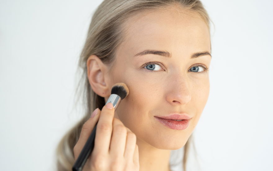 Frau verblendet make-up mit pinsel