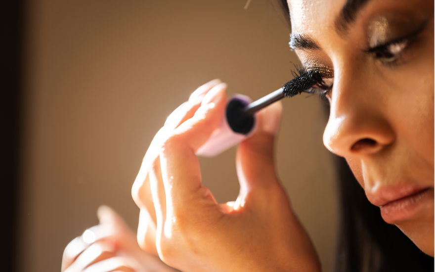 Frau tuscht ihre Wimpern nahaufnahme