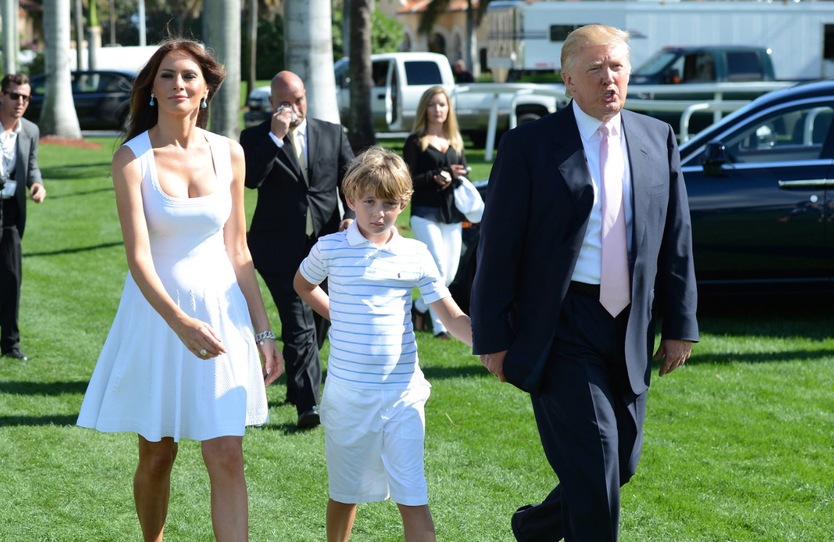 Melania und Donald Trumpt mit ihrem Sohn, Menschen im Hintergrund