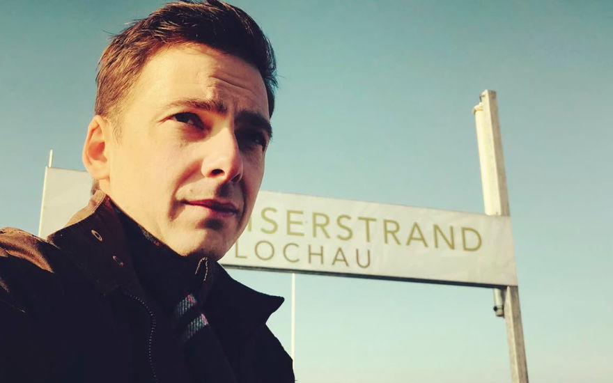 Stefan Pohl macht vor einem Schild ein Selfie