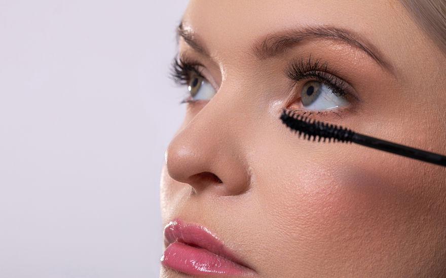 Frau tuscht Wimpern