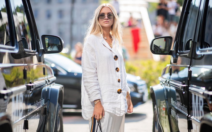 Eine Frau in einer weißen Bluse und angesagter Sonnenbrille