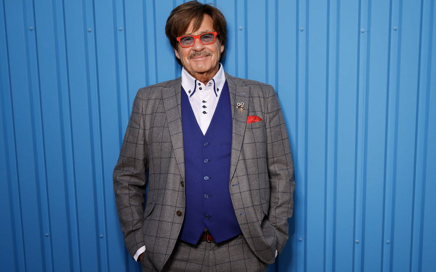 Fernsehmoderator Jörg Draeger lächelt im grauen Anzug