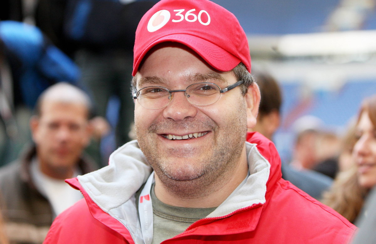 Elton lächelt mit roter Kappe