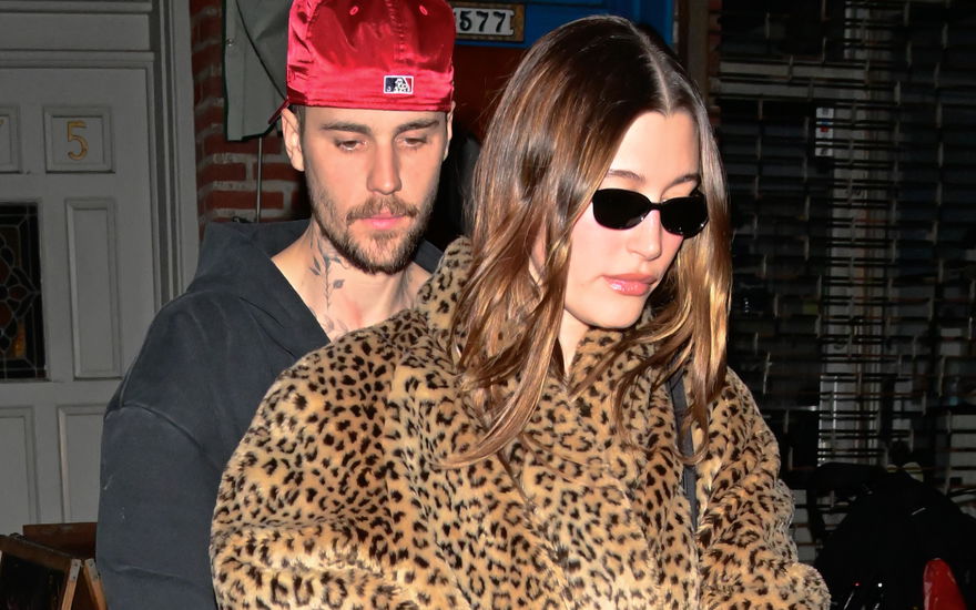 Justin Bieber guckt mit Cappy nach unten, Hailey Bieber mit Sonnenbrille und Leoparden-Jacke