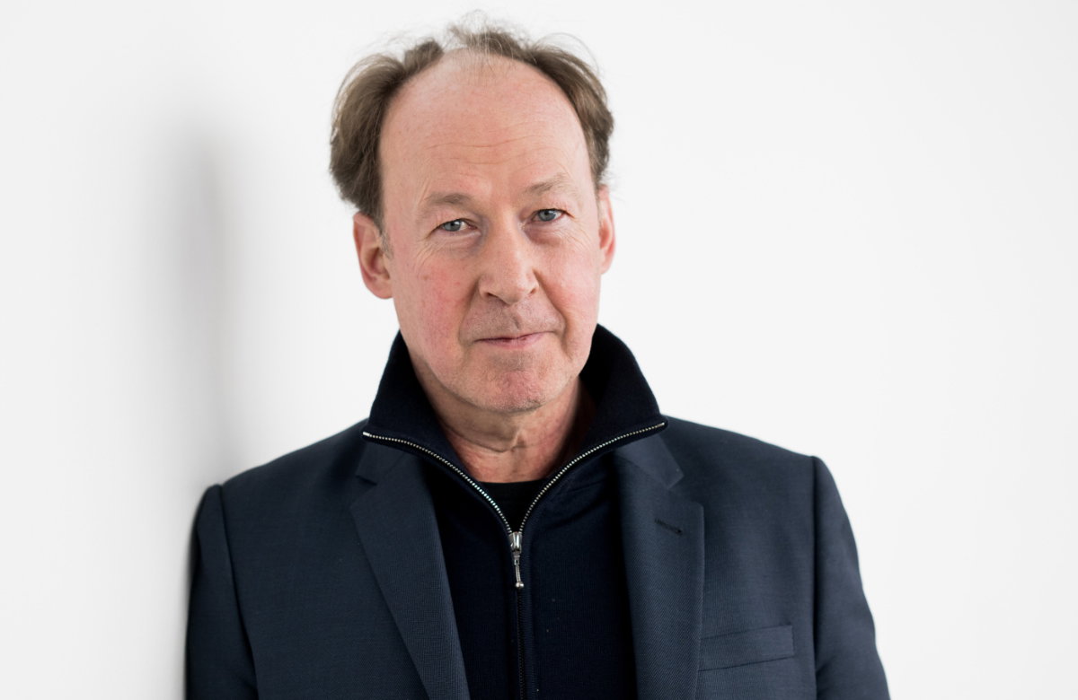 Ulrich Noethen vor einer weißen Wand