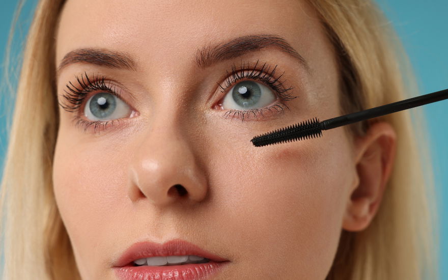 Frau tuscht Wimpern