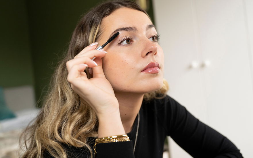 Frau tuscht sich Wimpern an