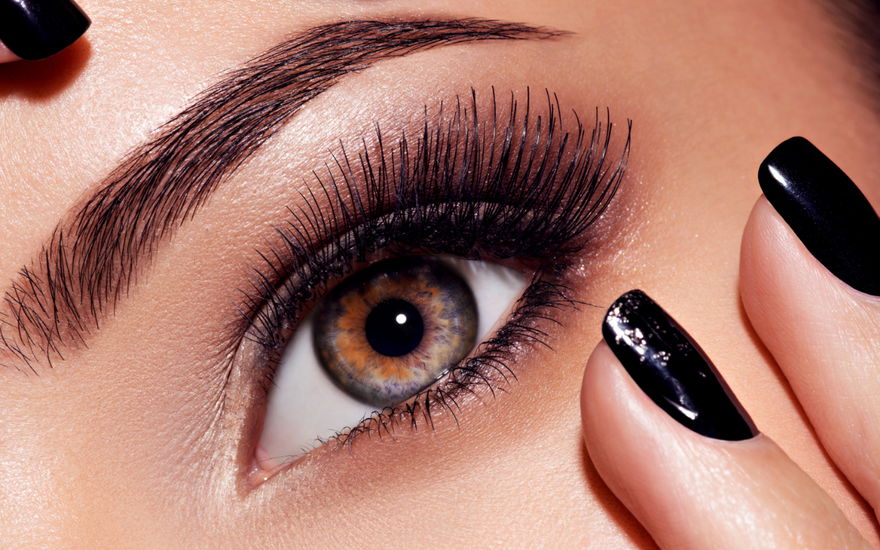 Frau mit langen Wimpern und schwarzen Nägeln