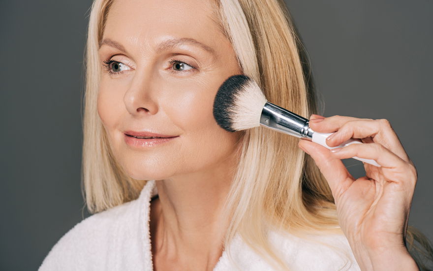 Reife Frau trägt Make-up auf