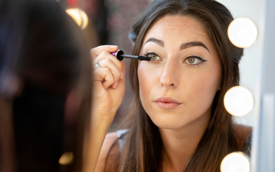 Frau tuscht Wimpern an