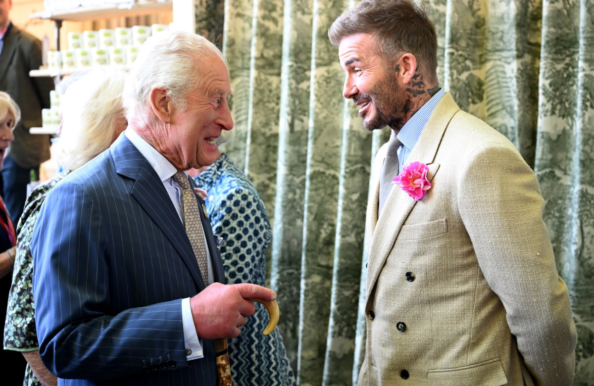 König Charles und David Beckham stehen sich gegenüber und lachen