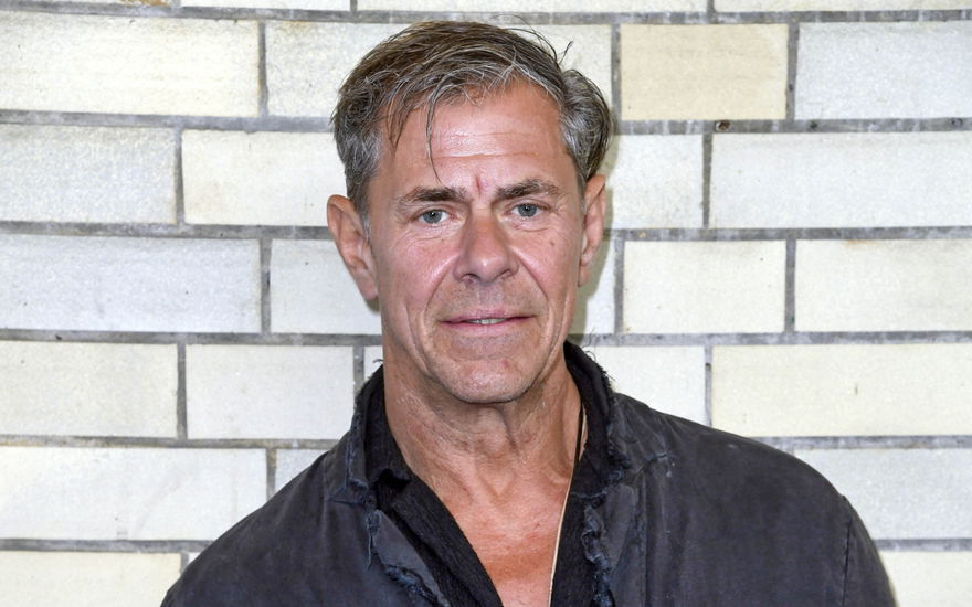 Sven Martinek steht vor einer Wand