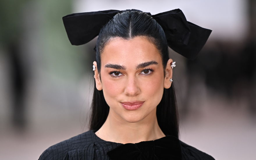 Dua Lipa mit großer schwarzer Schleife im Haar