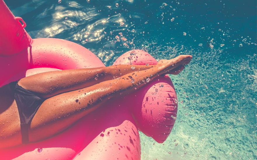 Eine Frau liegt auf einer Luftmatratze im Pool