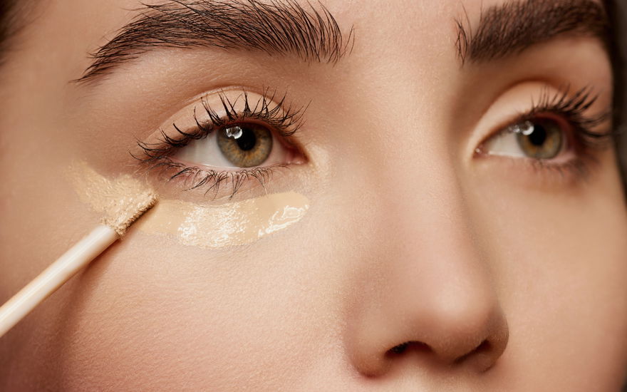 Frau schminkt Concealer