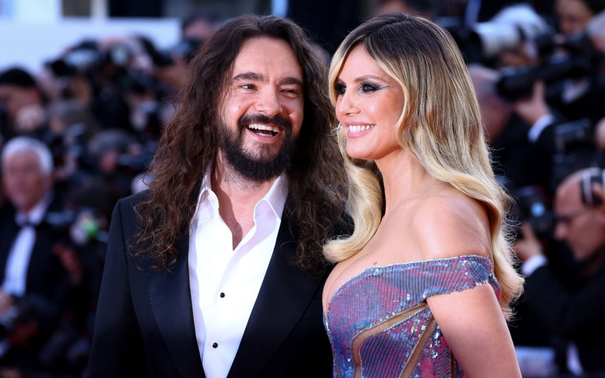 Tom Kaulitz lacht Heidi Klum an, Fotografen im Hintergrund