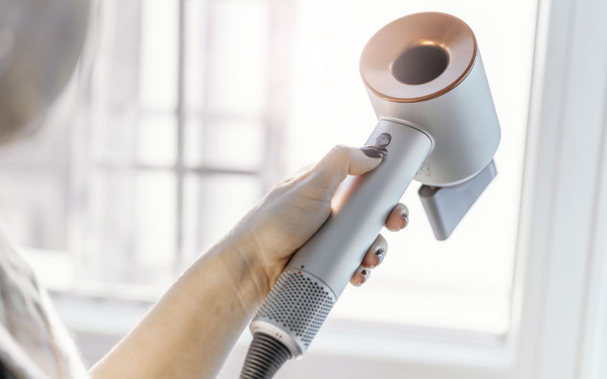 Frau mit Dyson-Föhn