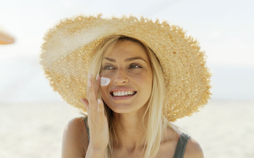 Blondine trägt Sonnenschutz auf