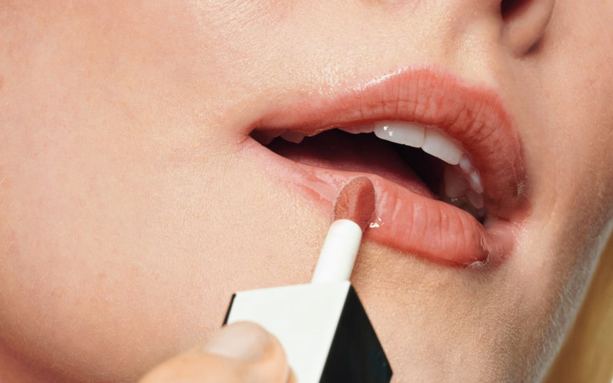 Frau trägt Lippenfarbe auf