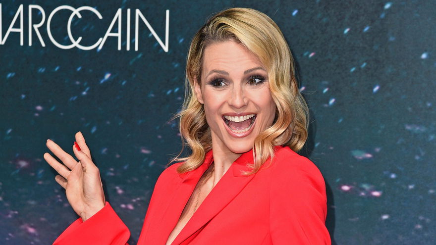 Michelle Hunziker lacht mit Zähnen zeigt Peace-Zeichen