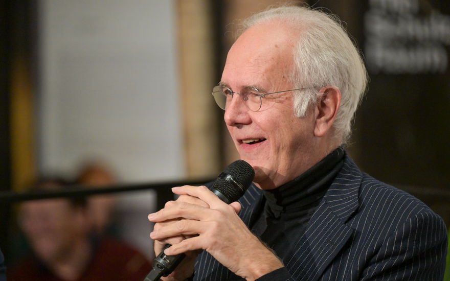 Harald Schmidt von der Seite mit einem Mikrofon in der Hand