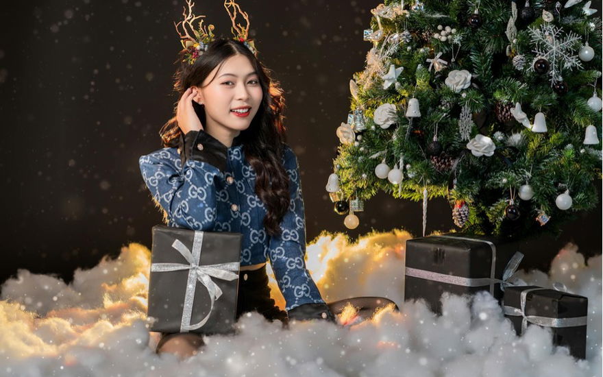 Eine Frau sitzt vor dem Weihnachtsbaum