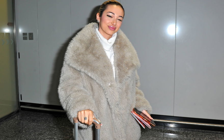 Ariel im Fake-Fur-Mantel am Flughafen