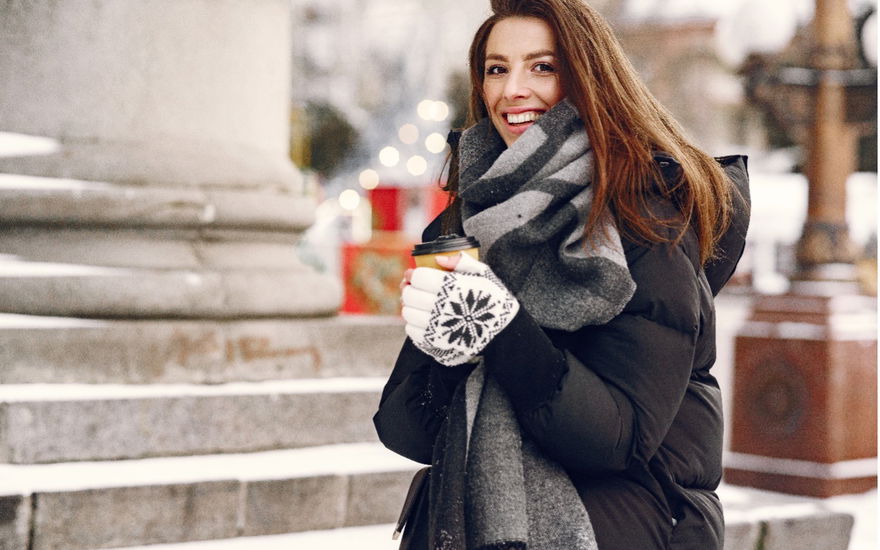Eine Frau mit wärmender Winterjacke und einem dicken Schal