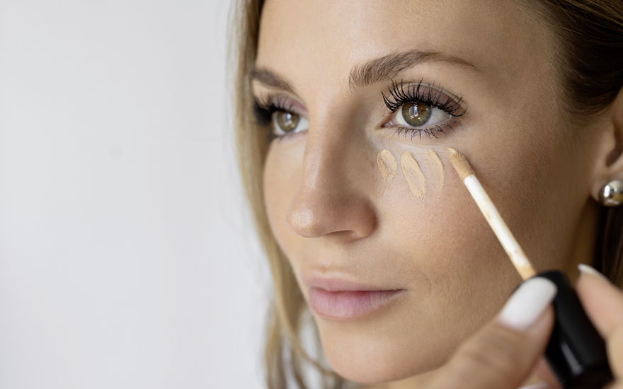 Frau trägt Concealer auf