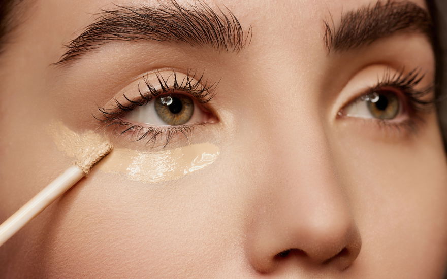 Frau trägt Concealer auf