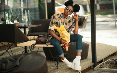Eine junge Frau mit Jeans und buntem Shirt