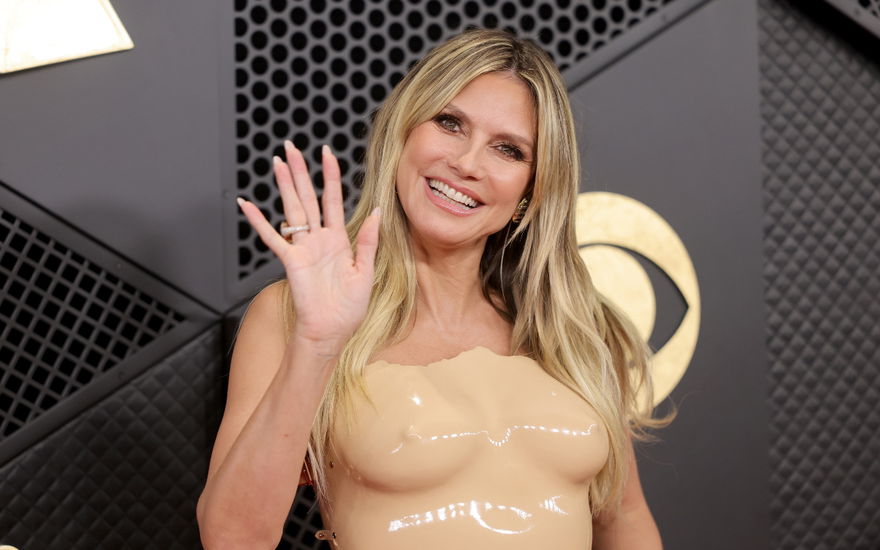 Heidi KLum winkt und lächelt im Nackt-Kleid