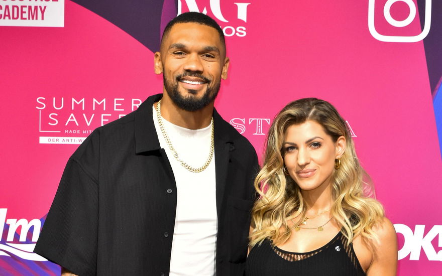 Dominic und Sarah Harrison vor einer pinken Wand