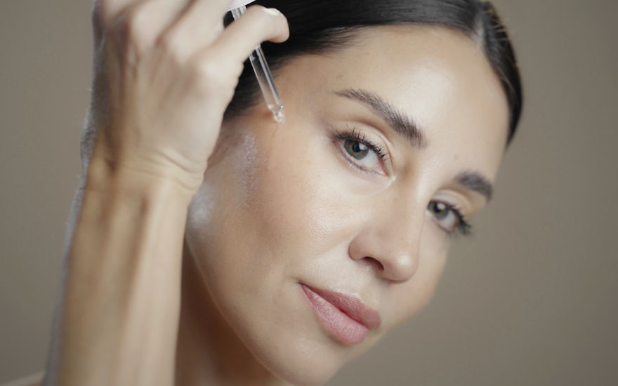 Frau mit Anti-Aging-Serum-Pipette