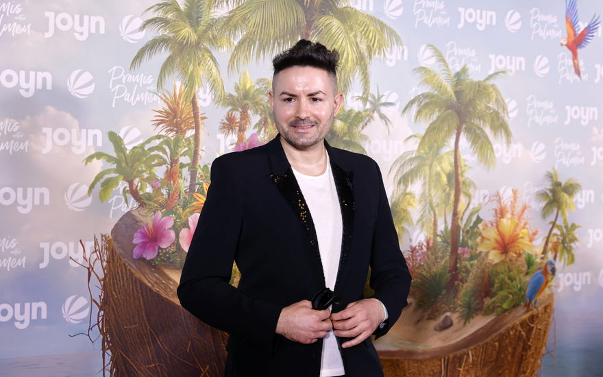 Menderes Bagci lächelt bei der Premiere von "Promis unter Palmen"