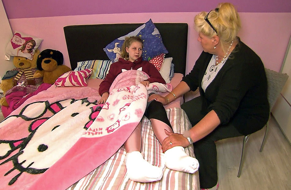 Loredana Wollny liegt im Bett, Mama Silvia Wollny sitzt neben ihr