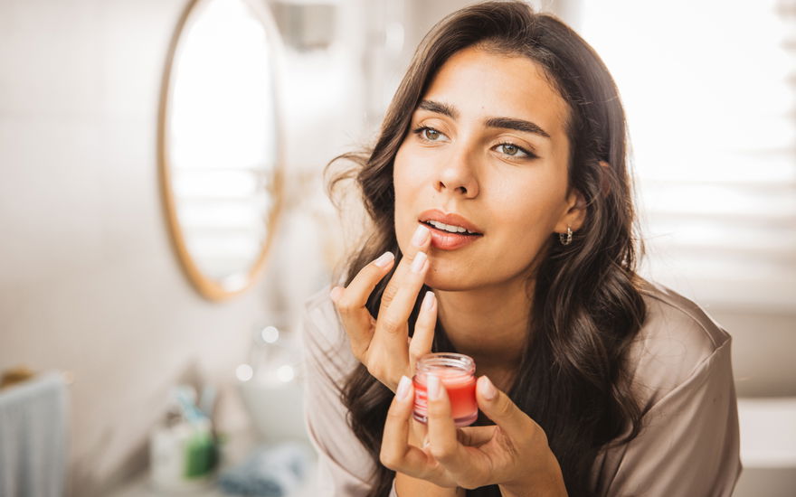 Frau trägt Lippenpflege auf