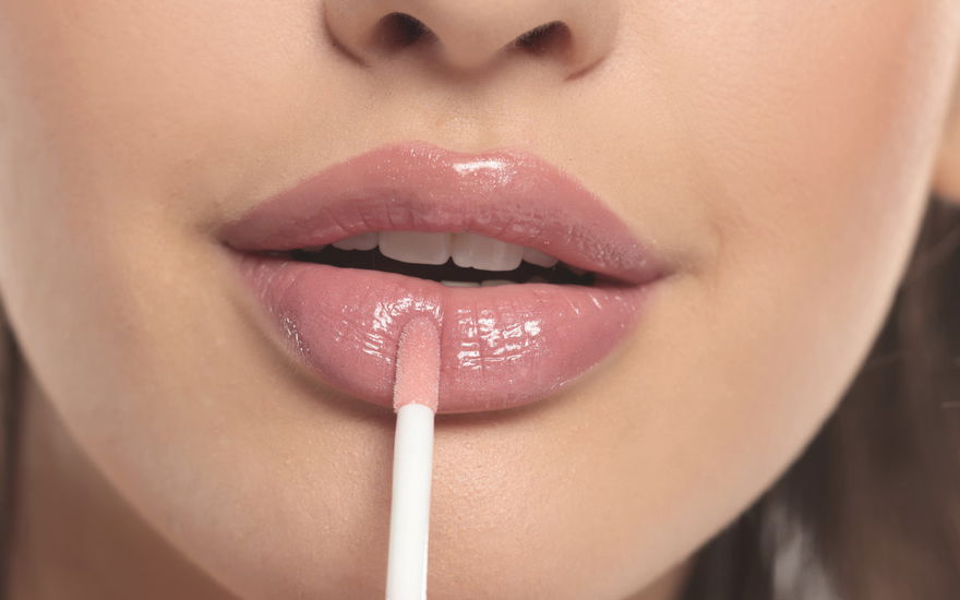 Frau trägt Lipgloss auf