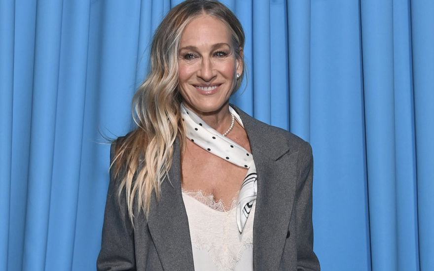 Sarah Jessica Parker strahlt vor blauen Vorhang
