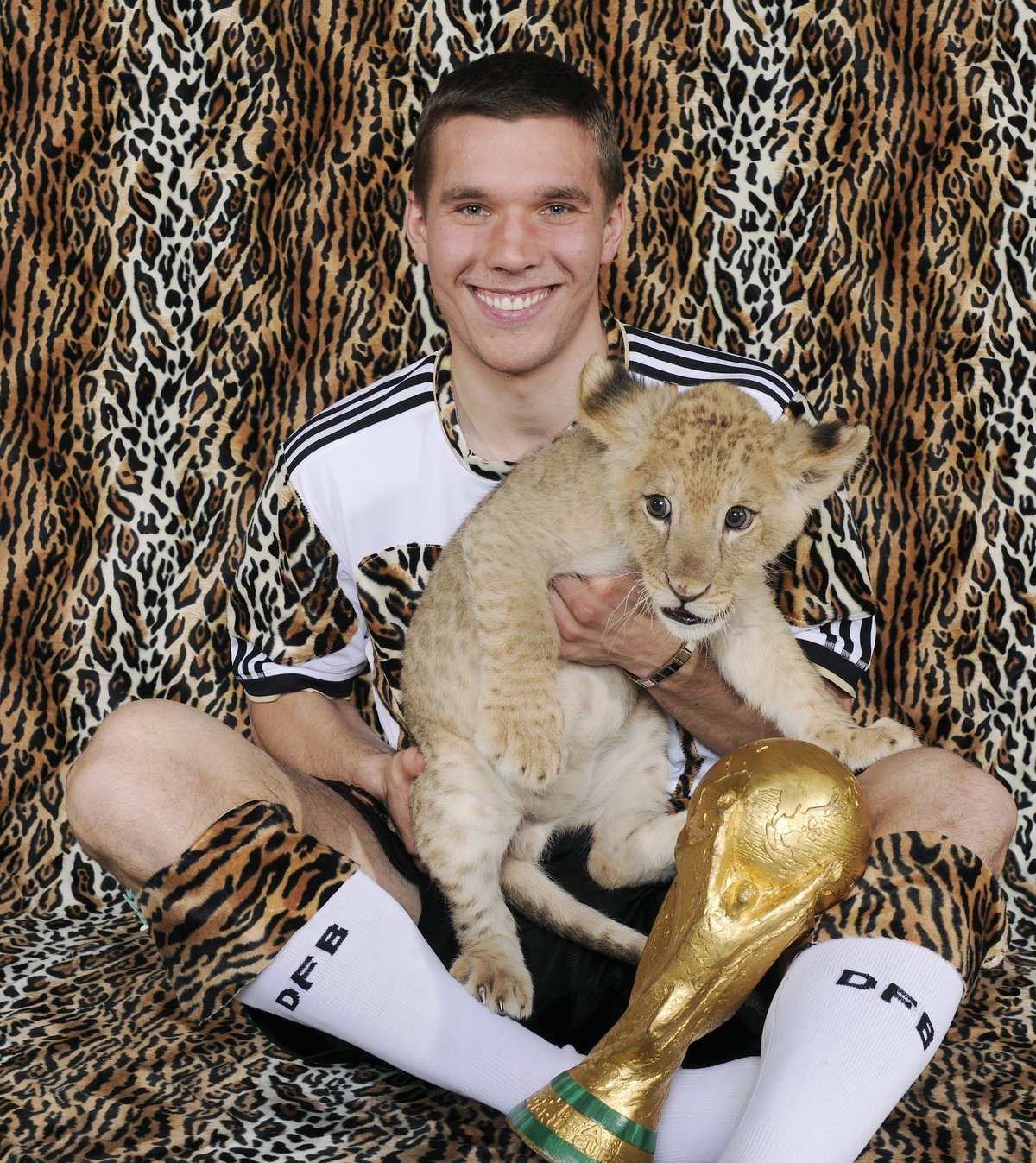 Lukas Podolski mit einem Löwen-Baby im Rahmen des WM-Shootings 2010