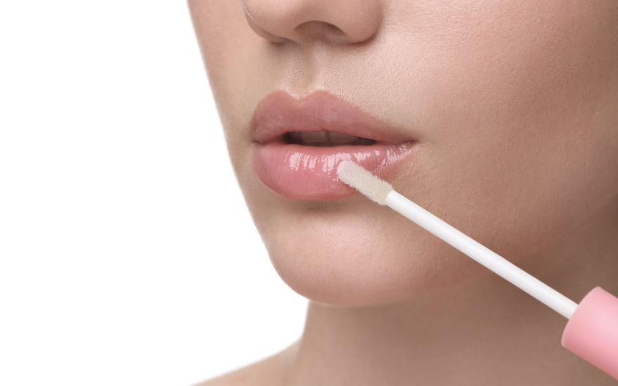 Frau trägt Lippenöl auf