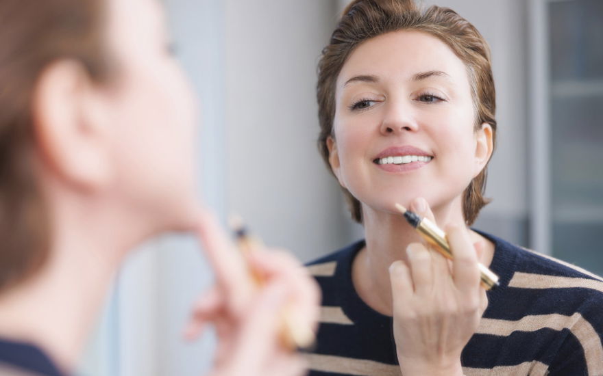 Frau trägt Concealer auf