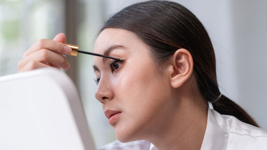 Frau malt Wimpern an