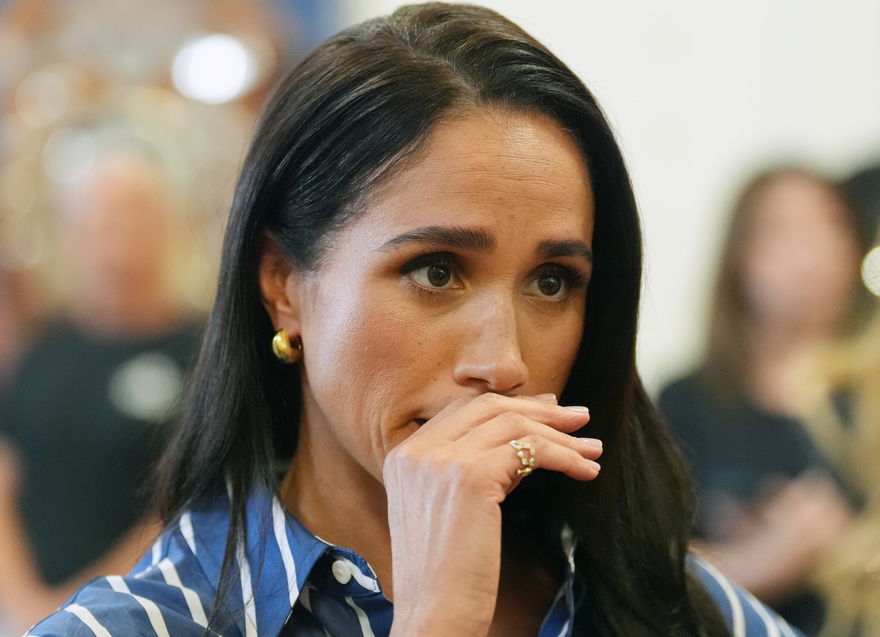 Herzogin Meghan guckt traurig und hat die Hand vor dem Mund