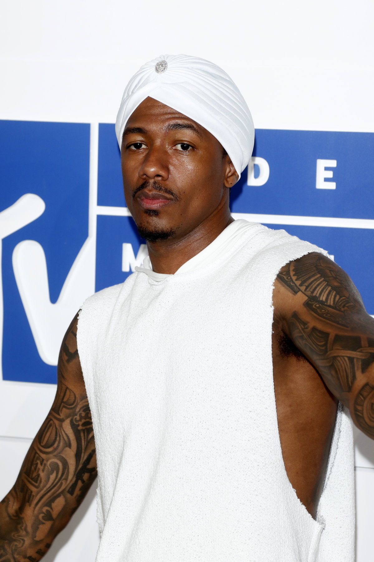 Nick Cannon mit trägt ein weißes Outfit mit Turban.