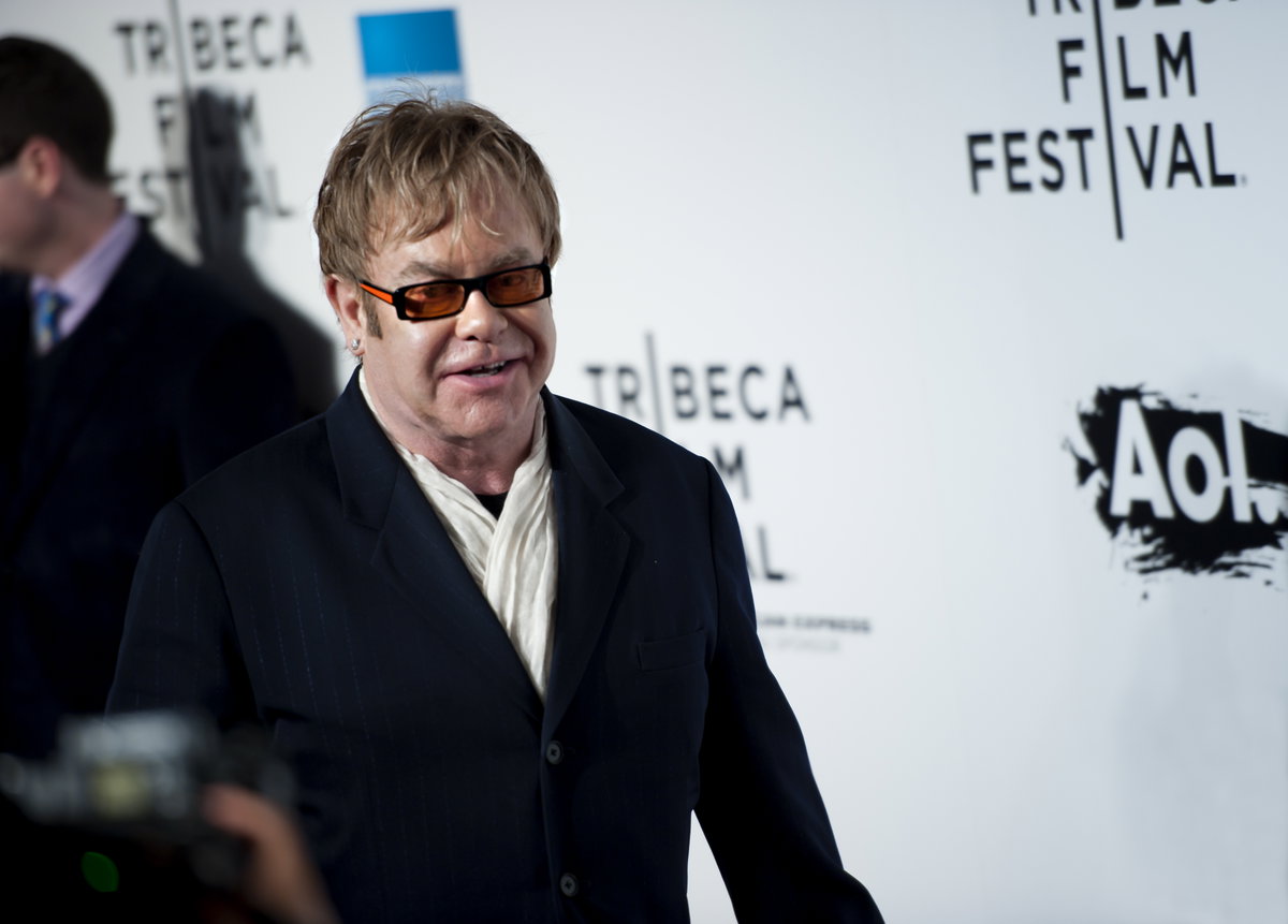 Elton John vor einer weißen Wand